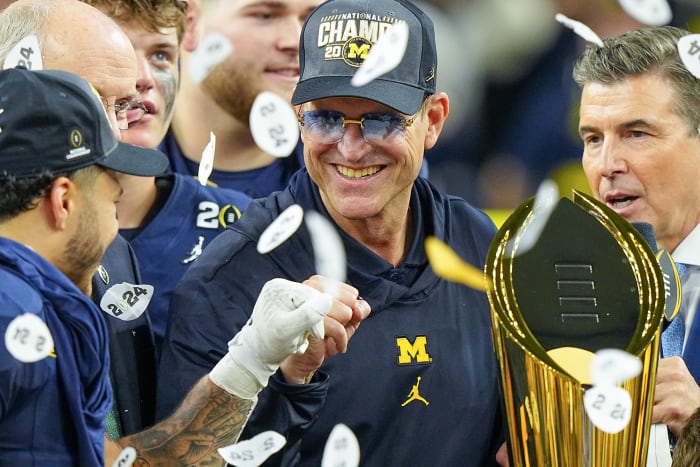 Confetti falls on Jim Harbaugh as he holds the national championship trophy after the title game.